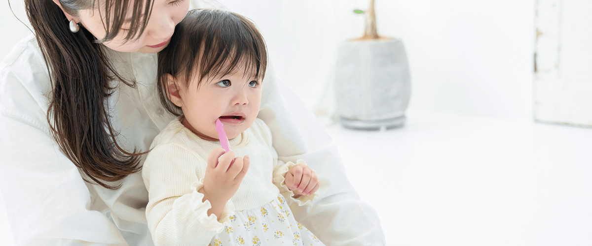 子供が歯みがきするのを見守る母親
