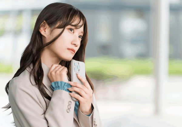 スマホをもって悩む女性